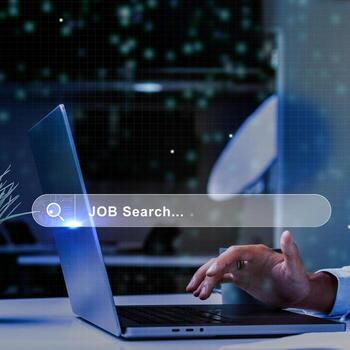 Person using laptop for job search in modern workspace during evening hours with digital interface elements photo