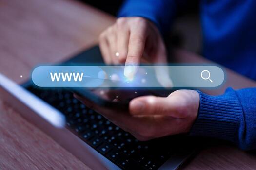 Searching for information online using a smartphone during evening hours while seated at a desk photo