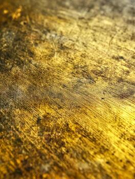 Close-up of a textured gold-colored surface with scratches and wear photo