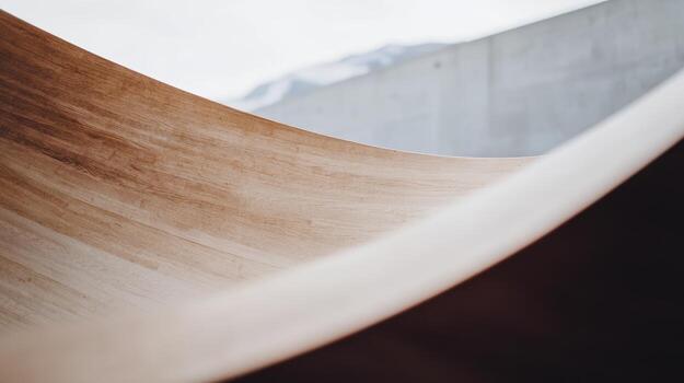 Wooden curves showcase craftsmanship in a modern architectural setting with mountains in the background photo