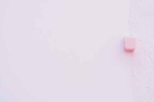 Pink corner block against a smooth white wall creates a minimalist aesthetic in a bright space photo