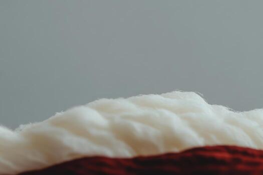 Soft white fiber intertwined with vibrant red yarn in a close-up view photo