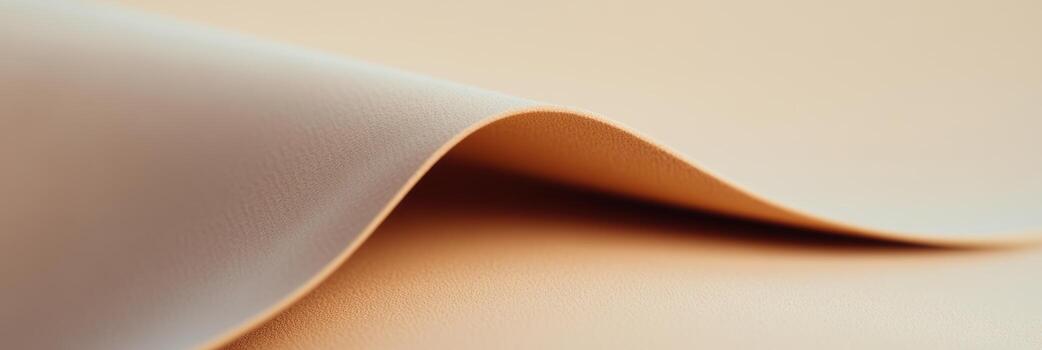 Smooth curves of soft paper texture reflecting light in subtle shades of beige and peach photo