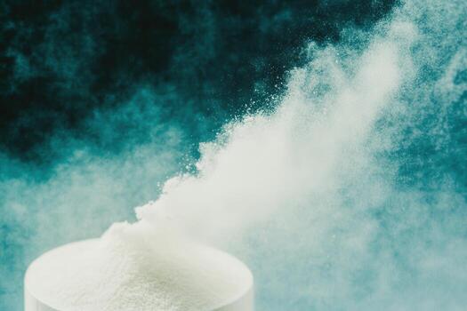 White powder explodes from a container against a vivid background photo
