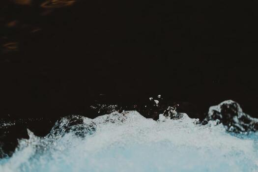 Water splashes gracefully against a dark background in an artistic portrayal of movement and texture photo