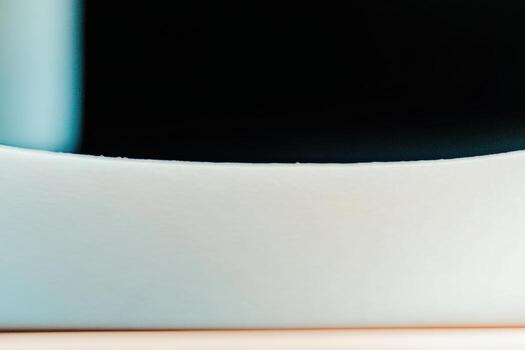 Close-up of a simple white ceramic bowl on a wooden surface with a dark background photo
