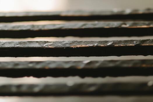 Close-up view of textured metal bars under soft light revealing intricate details and unique patterns photo