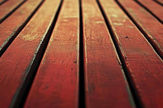 Close-up view of red wooden planks on a deck in bright sunlight during midday photo