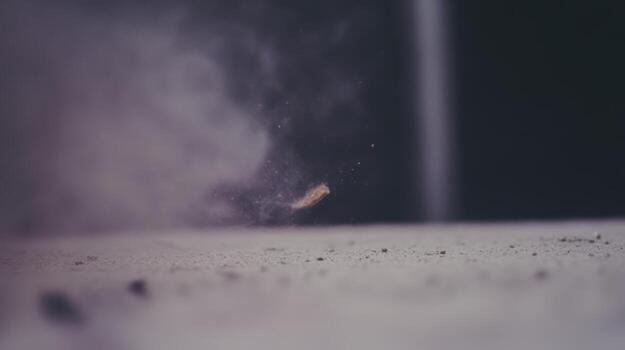 Dust and particles scatter from the ground after a sudden impact in an indoor setting photo