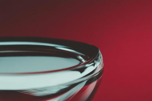Close-up of a clear glass bowl against a vibrant red background highlighting its elegant design photo