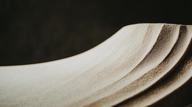 Textured surface displaying layers of smooth curves and gentle gradients in soft lighting photo