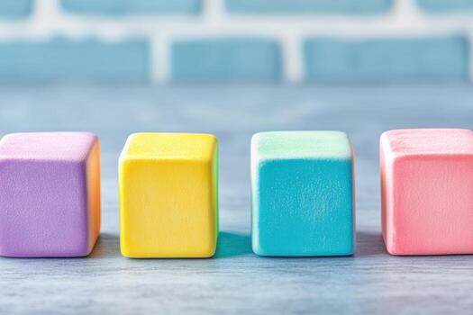 Colorful wooden blocks arranged in a row on a light surface with a blue background photo