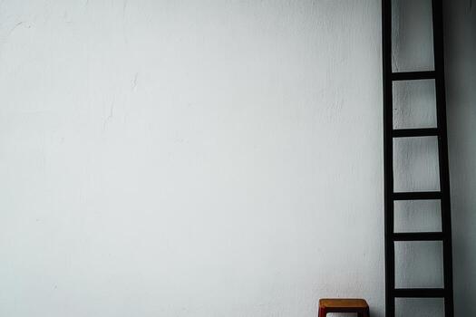Ladder and stool against a plain white wall in a minimalistic interior setting photo