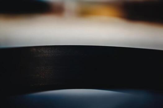 Close-up view of curved metal surface reflecting soft light at an abstract angle photo