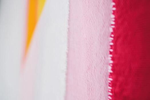 Vibrant abstract texture of colorful fabric with red, pink, yellow, and white hues displayed photo