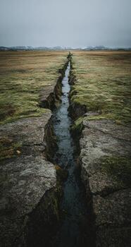 A long narrow stream running through a field photo