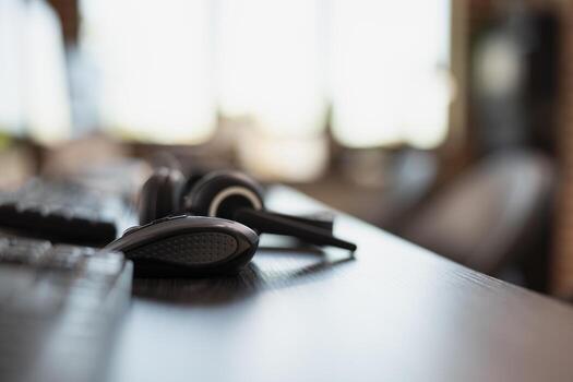 Close up of mouse placed near wired headset and keyboard on a desk. Selective focus on computer hardware setup well arranged on the table in preparation for use by office workers. photo