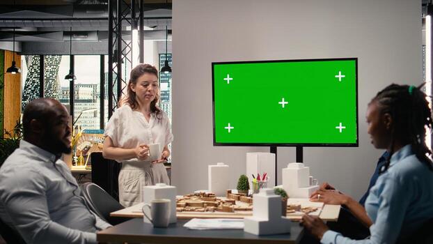 diverso equipo explorador zonificación regulaciones siguiente a aislado mostrar, reunión para ciudad planificación estrategias con arquitectónico 3d modelos y diseño herramientas para sitio preparación y desarrollo. foto