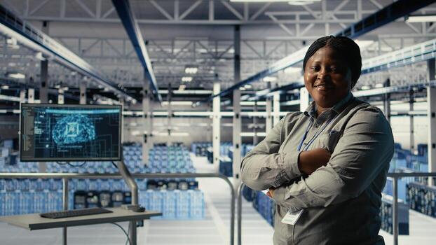 Portrait of smiling IT professional in server farm optimizing machine learning systems handling tasks. Happy data center female engineer adjusting neural networks AI model parameters, camera A photo