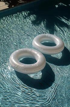 White Inflatable Rings Floating on the Surface of a Clear Swimming Pool During Sunny Weather photo