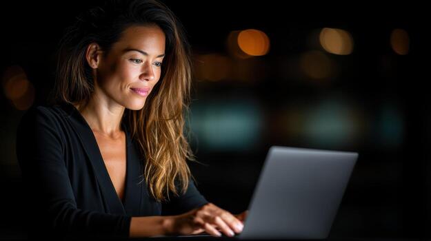 A woman is typing on a laptop computer photo