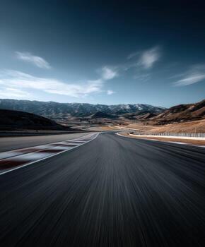 A long exposure photograph of a road with mountains in the background photo