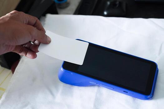 un blanco blanco Cajero automático tarjeta adjunto a un edc máquina. un Bosquejo de un crédito tarjeta con nfc funcionalidad. financiero tecnología concepto. foto