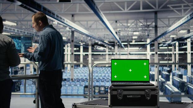 Data center programmers deploying deep learning software on rigs using green screen laptop. Server hub coworkers train AI systems with datasets using mockup notebook to support applications, camera A photo
