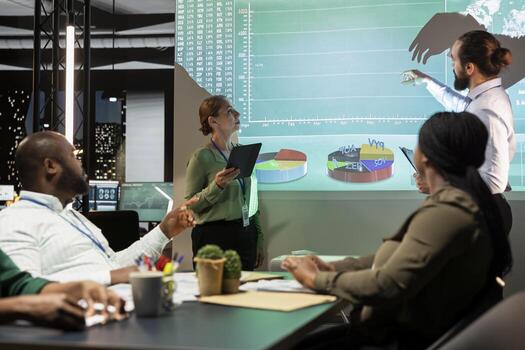 Diverse group of corporate associates look into project timelines and agenda, creating a strategy for development after hours in conference room. Goal setting in a business environment. photo