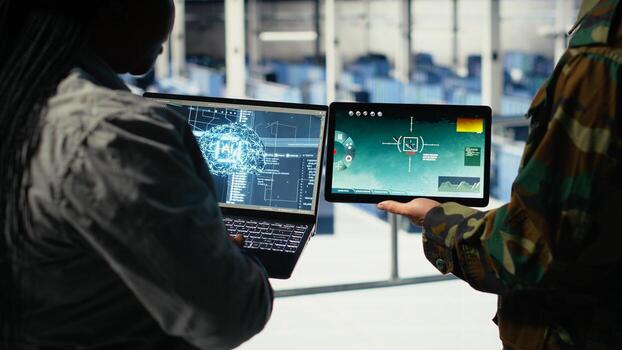 Close up of army general and coworker in data center integrating AI into radar systems for missile tracking. Teamworking soldier and technician in server hub analyzing aerial movement on device, camera B photo