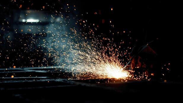 A person is welding with sparks in the dark photo