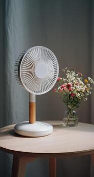 A fan on a table with flowers in the background photo