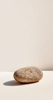 A stone sitting on top of a white surface photo