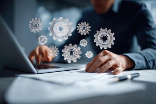 A man is using a laptop with gears on it photo