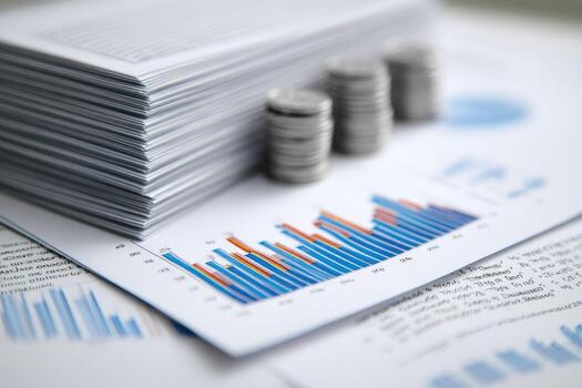Stack of coins and papers with financial graphs photo