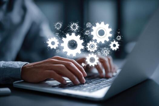 A person typing on a laptop with gears on the screen photo