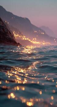 A view of the ocean at dusk with lights shining on it photo