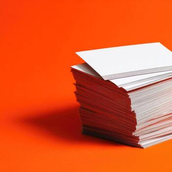 Stack of white business cards on orange background photo