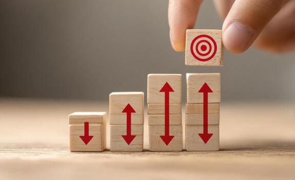 A person is placing wooden blocks with arrows pointing up photo