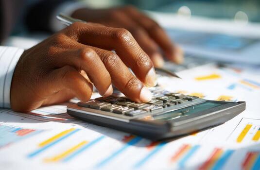 A person is using a calculator on a desk photo