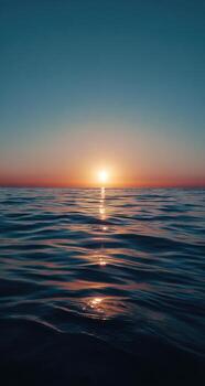 The sun setting over the ocean photo