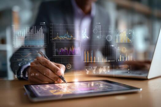 Businessman using tablet with graphs and data on screen photo