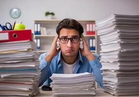 Stressed office worker overwhelmed by paperwork at desk photo