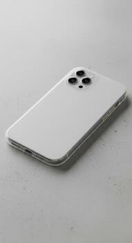 Modern white smartphone with a triple camera in a clear protective case on a grey textured background. photo
