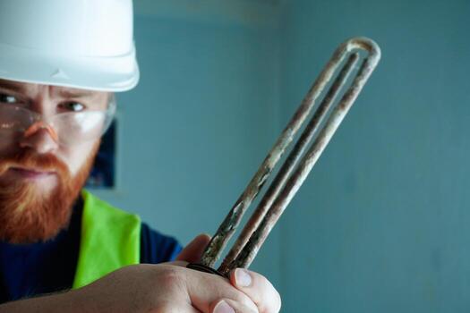 Humorous concept of maintenance worker displaying corroded heating element in heroic pose. Creative approach to technical documentation with cinematic warrior-like presentation style. photo
