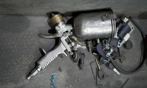 Close-Up of Spray Gun and Equipment on a Workshop Table Surface photo