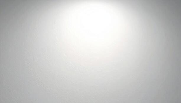A plain, light gray wall texture, illuminated by a focused light source, showcasing subtle surface variations. photo