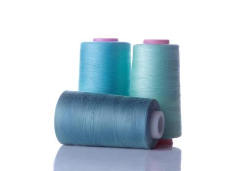 bobbin with threads in blue tones on a white isolated background. photo