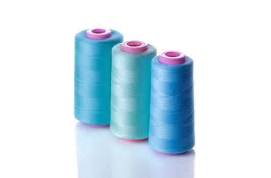 three spools of thread on a white background photo