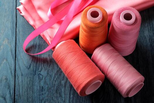 Colorful sewing threads and ribbons on fabric photo